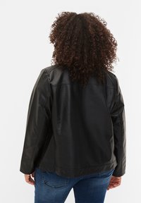 Veste en cuir noir au fit décontracté, épaules arrondies et texture lisse. Présente des coutures minimales et un design de col basique.