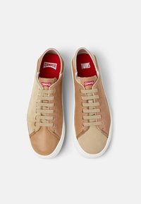 Hnědé a béžové tenisky s kombinací textur, s bílými podrážkami, béžovými tkaničkami a červenými vložkami s nápisy "CAMPER" a "TWINS."