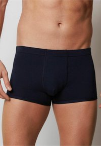 Mörkblå boxershorts tillverkade av mjukt, elastiskt tyg. Har en figurnära design med kontrasterande sömmar och en medelhög midja.