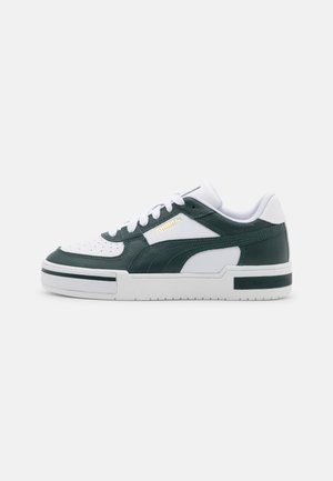 Zapatillas con parte superior de cuero y material sintético en color verde oscuro y blanco, con puntera perforada, cordones, suela blanca gruesa y detalles en logo dorado.