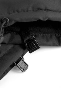 Musta kangaskassi, jossa on sileä pinta, mustasta muovista valmistettu varuste, soljet ja vetoketju, osittain auki, jotta sisävuori näkyy.