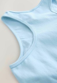 Hele halli puuvillane tank top sileda tekstuuriga, laiad rihmad, kaardus kaelus ja tugevdatud õmblused äärte juures.