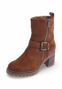 Bottines en suède marron avec fermeture éclair sur le côté, accent de boucle et talon épais. Elles présentent un bout rond et une semelle en caoutchouc texturé.
