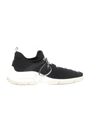 Zwarte instapsneaker met witte dikke zool, elastische gebreide bovenkant en zwarte band met geknoopte veters aan de zijkant, gezien van rechts.