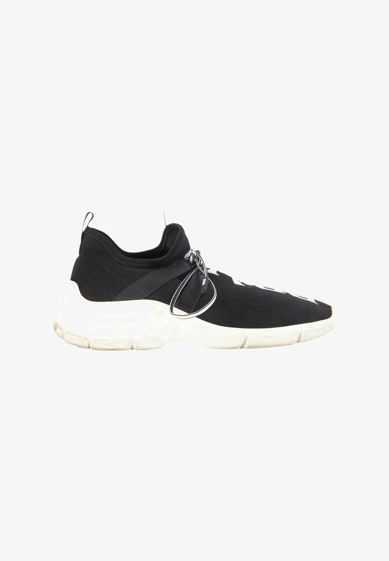 Baskets noires sans lacets avec semelle blanche épaisse, tige en maille élastique et bride noire avec lacets noués sur le côté, vues de profil droit.