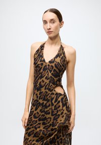 Robe imprimé léopard en tissu marron et noir ; design à col licou avec une découpe latérale et un drapé fluide. Texture lisse, matériau léger.