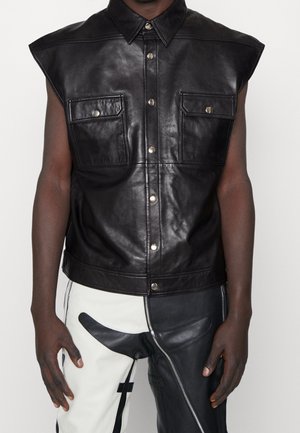 Gilet senza maniche in pelle nera con colletto a punta, due tasche sul petto e chiusura a bottoni a pressione. Tessuto liscio con una leggera lucentezza.