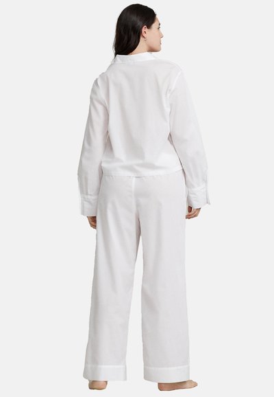 Completo pigiama in cotone bianco composto da una camicia con colletto e pantaloni a gamba larga. I dettagli includono una texture liscia e polsini e orli risvoltati.
