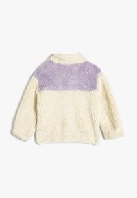 Pull en fausse fourrure avec un col montant, présentant un corps crème et une partie supérieure lavande douce, mettant en valeur une texture chaleureuse et confortable.