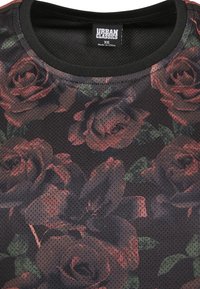 Black mesh shirt featuring a floral pattern in dark red roses, with green leaves, finished with a black crew neck. Urban Classics label visible.