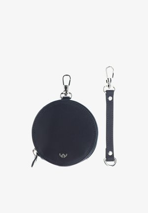Pochette ronde en cuir noir pour pièce de monnaie avec fermeture éclair et fermoir en métal, présentée avec une sangle en cuir noir amovible avec des fermoirs métalliques aux deux extrémités.