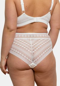 Ensemble de lingerie en dentelle blanche avec des motifs géométriques, une texture douce et des détails de finition délicats ; comprend un bas taille haute et des bretelles ajustables.