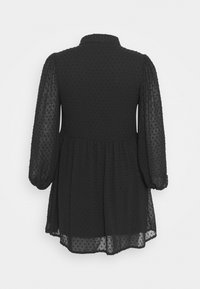 Černé šifónové šaty s nabíranými dlouhými rukávy, tečkovanou strukturou a gumičkou v pase. Vybavené vysokým výstřihem a lehkou, volnou dolní částí.