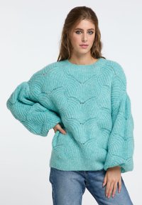 Türkiser, übergroßer Pullover aus gestricktem, strukturiertem Material mit einem Wellenmuster, breiten Ärmeln und einem Rundhalsausschnitt.