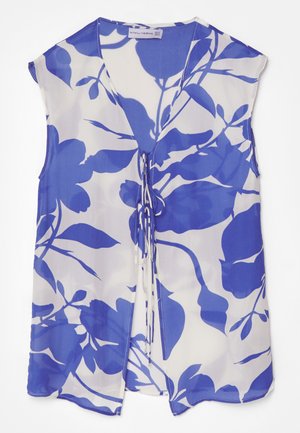 Blouse sans manches en tissu transparent, avec un motif floral bleu sur fond blanc, décolleté en V et détails à nouer à l'avant.