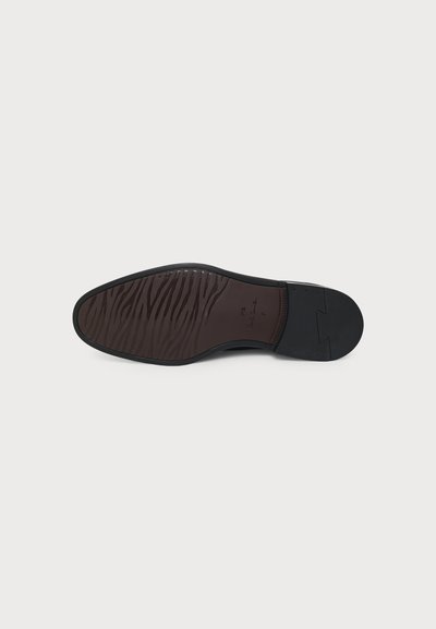 Semelle d'une chaussure de ville noire avec l'avant marron texturé, talon noir lisse et marquage taille 7 sur fond clair uni.