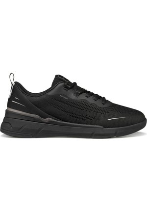 Baskets de sport noires basses avec tige en mesh, fermeture à lacets, semelle épaisse et languette au talon pour un enfilage facile.