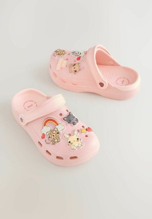 Rozā klumpes no viegla materiāla ar caurumiem ventilācijai un krāsainām dekoratīvām uzlīmēm ar dzīvniekiem un simboliem.