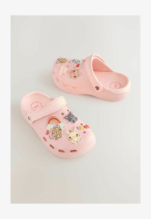 Rožiniai klumpės iš lengvos medžiagos, turinčios angas orui praleisti ir spalvingus dekoratyvinius lipdukus su gyvūnų ir simbolių motyvais.