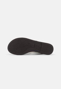 Semelle de chaussure en caoutchouc noir avec motif de grip texturé et indication de taille 42, présentée sur fond blanc.
