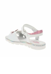 Sandalias blancas con una correa rosa brillante, acento floral en la parte frontal, plantilla acolchada y suela de goma blanca flexible con un borde iridiscente.