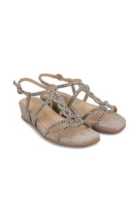 Beige suède wedge sandalen met decoratieve zilveren studs, met een strap-design en open teen. Inclusief een verstelbaar enkelriempje.