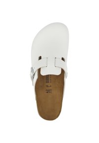Zoccoli bianchi in pelle con fibbia regolabile in metallo argentato, tacco aperto e soletta in pelle marrone con texture. Presentano ritagli sulla parte superiore per una maggiore traspirabilità.