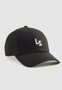 Gorra de béisbol negra hecha de tela, con un logotipo bordado "LS" en blanco en la parte frontal, con visera curva y agujeros de ventilación.