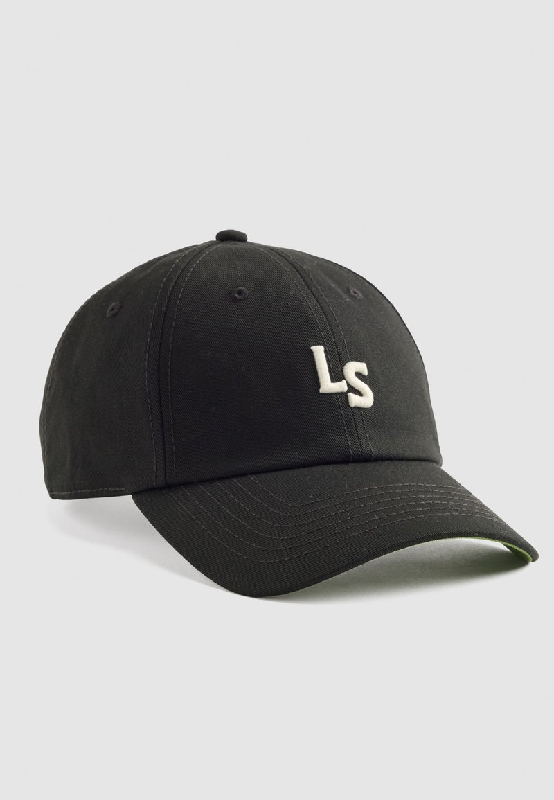 Gorra de béisbol negra hecha de tela, con un logotipo bordado "LS" en blanco en la parte frontal, con visera curva y agujeros de ventilación.