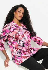 Bunte bedruckte Bluse mit Rundhalsausschnitt, langen Ärmeln und abstrakten Mustern in pink, rot, schwarz und weißen Texturen.
