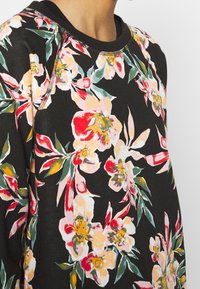 Zwarte sweatshirt met bloemenpatroon in levendige roze, gele en groene kleuren; voorzien van een ronde halslijn en contrasterende stikdetails.