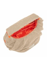 Borsa beige con texture e un esterno morbido in peluche, foderata in arancione e con chiusura a zip. Presenta un design raccolto unico e una patch con logo sul lato.