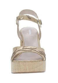 Sandali con tacco a cuneo beige dalla texture intrecciata, con cinturino alla caviglia e decorazioni in foglia metallica sul cinturino. Fodera interna morbida.