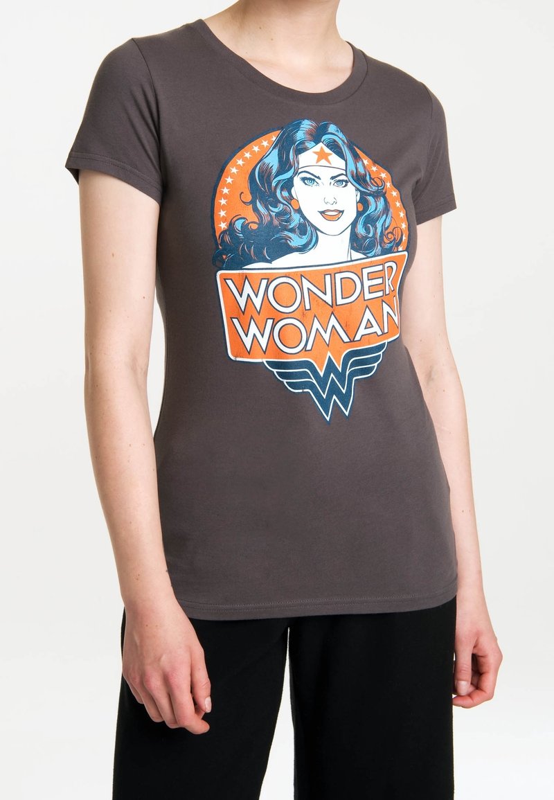 Šedé bavlněné tričko s velkým barevným potiskem Wonder Woman, modrými vlasy, červenou hvězdou a výrazným oranžovým textem na černém pozadí.