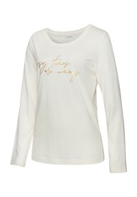 Cream long-sleeve shirt in soft cotton with a rounded neckline and golden cursive text "Cozy times are coming" on the front.