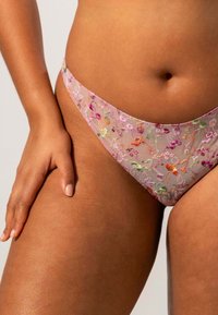 Nerveus roze ondergoed met bloemenborduursel in verschillende kleuren. Hoog uitgesneden ontwerp met een gladde textuur en delicate afwerking langs de randen.