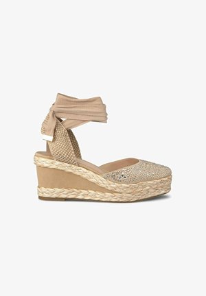 Beige wedge sandaal met stoffen enkelstrikken, geweven details en een versierde bovenkant met rhinestones. Jute-stijl gevlochten zool.