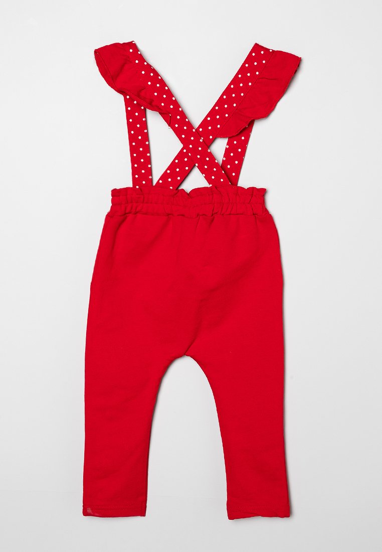 Rote Baumwoll-Latzhose mit Schulterfransen und weißen Punkten. Mit elastischem Taillengummi und schmalen Beinen.
