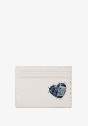 Porte-cartes en cuir blanc avec quatre fentes et un patch en denim en forme de cœur. Texture lisse avec des coutures contrastées.