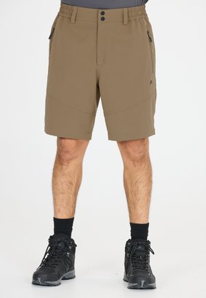Bruna vandringsshorts med en slät yta, elastisk midja, två framlåda och förstärkta sömmar, i kombination med svarta vandringsskor.