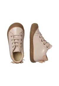 Ljust rosa, lackskor med bruna gummisulor, med runda snörningar och en lätt klack. Texturerad detalj runt sulan.