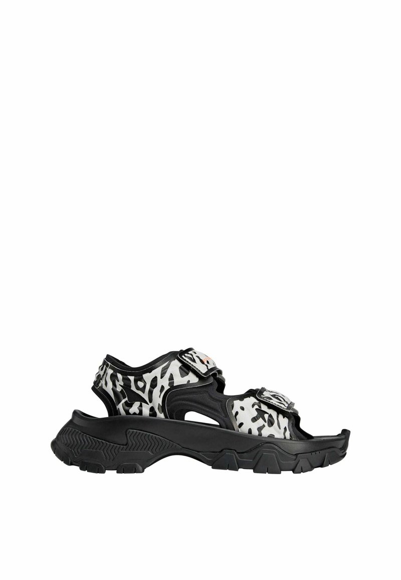 Zwart-witte sandalen met luipaardprint, voorzien van verstelbare banden, een gevormde voetbed en een gestructureerde zwarte rubberen zool.