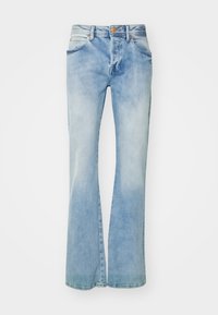 Pantalones vaqueros acampanados de color azul claro, confeccionados en denim, con un acabado desgastado, lazo para cinturón estándar y dos bolsillos frontales con detalles de costura visibles.