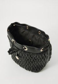 Schwarze Leder-Bucket-Tasche mit einer gesteppten Textur, goldenen Ösen-Akzenten und einem gebundenen Kordelzugverschluss. Innenfutter aus schwarzem Stoff.