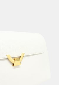 Borsa a tracolla in pelle bianca con un design strutturato, caratterizzata da una chiusura in metallo dorato e una texture liscia. Parte superiore piatta con bordi arrotondati.
