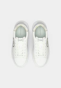 Hvite skinnsneakers med teksturerte sider, rund tupp og snøresystem. Har en logo på yttersiden og polstret krage for komfort.