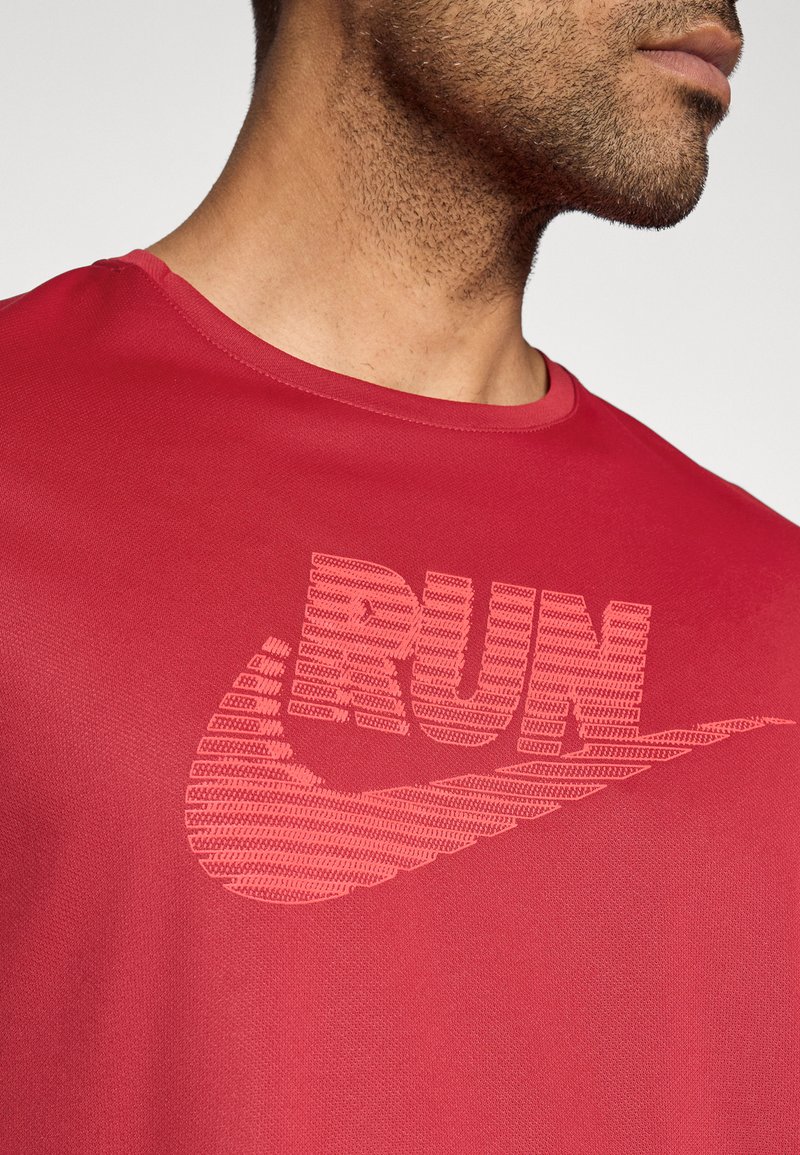 Rotes Sport-T-Shirt mit einer strukturierten "RUN" Grafik und Swoosh-Logo in einem etwas helleren Rot, rundem Ausschnitt und glattem Stoff.