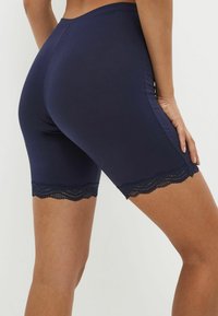 Marineblauwe shorts van een gladde stof, met een geschulpte kanten rand aan de zoom en een aansluitend ontwerp dat tot halverwege de bovenbenen reikt.