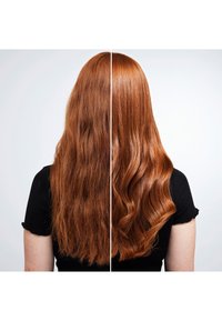 Lång röd hår som är delad i två sektioner: vänster sida lockig och frizzig, höger sida slät och glänsande, båda mot en ljus bakgrund.