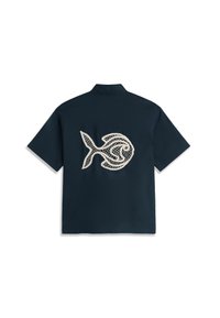 Chemise bleu marine à manches courtes avec col, ornée d'un grand motif de poisson brodé beige dans le dos.